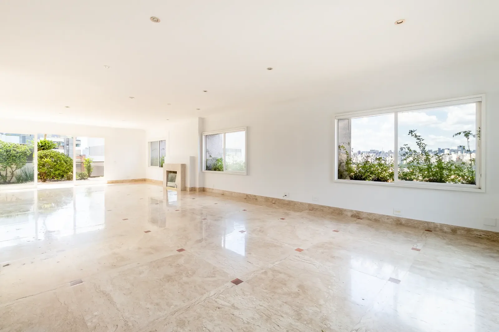Living atual da cobertura com piso claro, janelas amplas e integração com o terraço