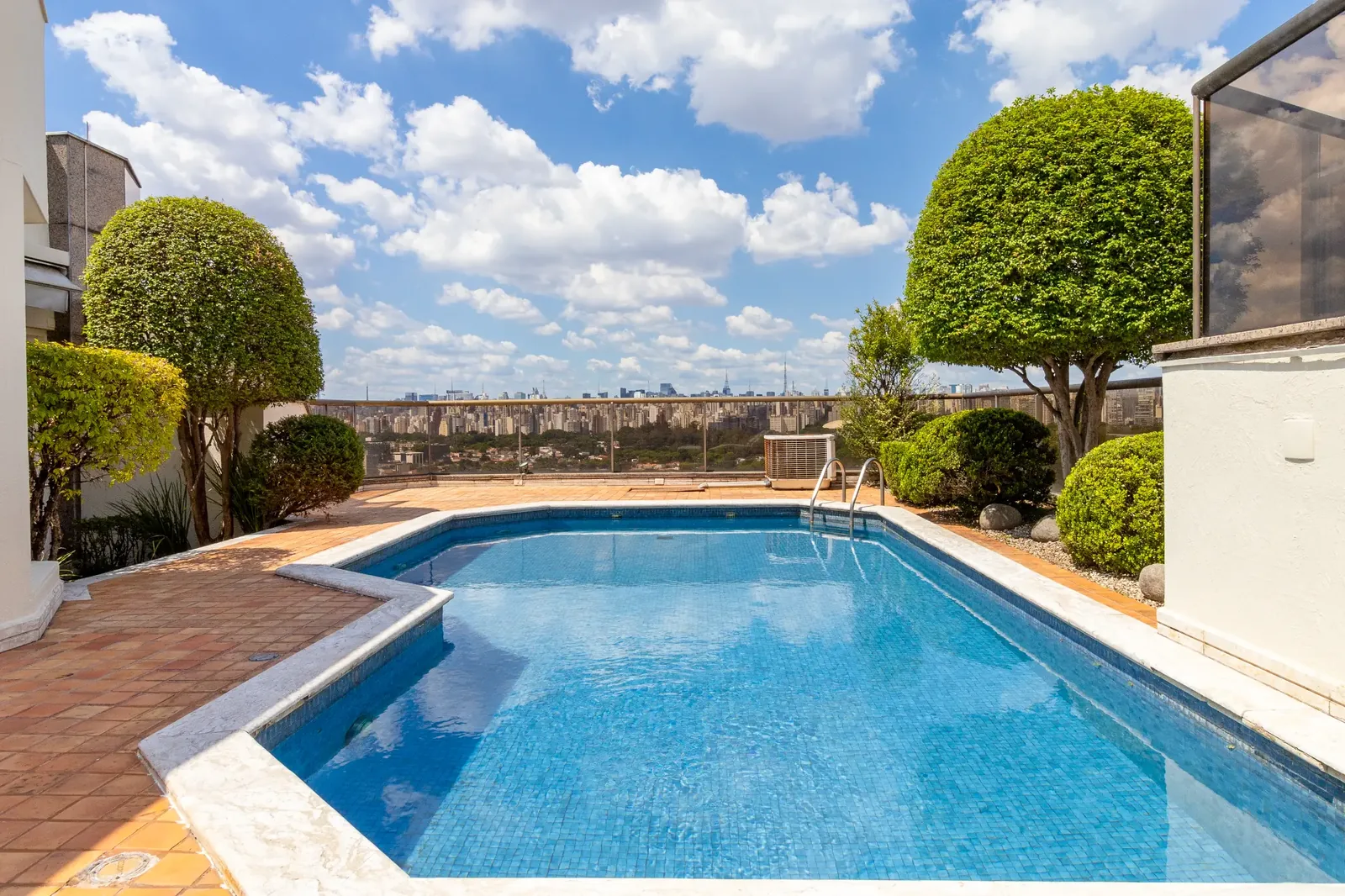 Piscina privativa real no rooftop, com céu, árvores e terraço ao redor