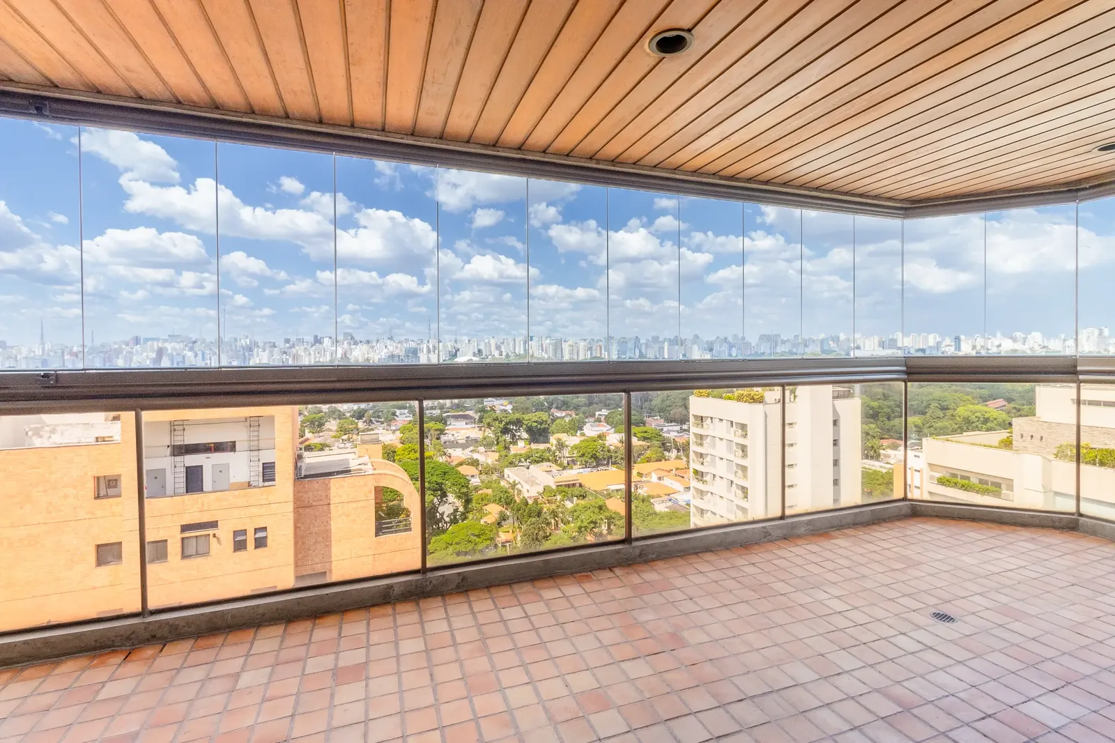 Terraço envidraçado atual com piso de cerâmica e vista aberta para a cidade